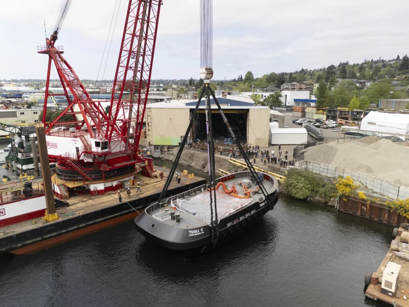 Image of the electric tugboat Tuuli C being lowered into the water for the first time in Seattle, Washington